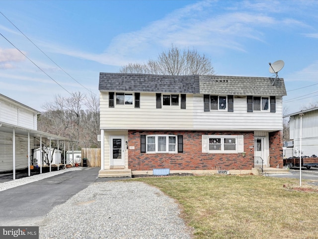 view of front of house featuring aphalt driveway, brick siding, roof with shingles, and a front lawn