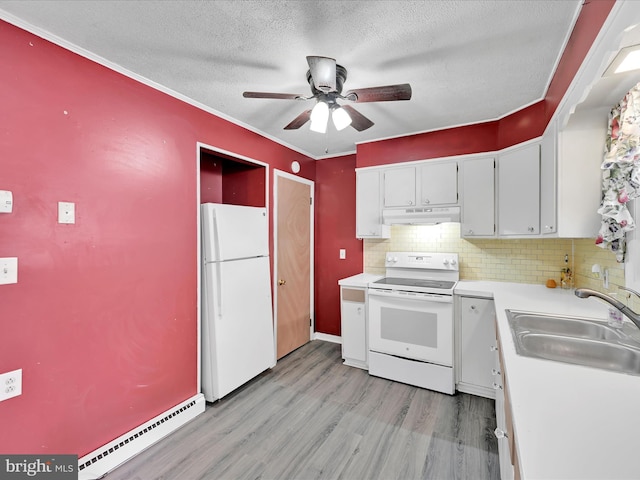 kitchen with white appliances, a sink, light countertops, under cabinet range hood, and a baseboard heating unit