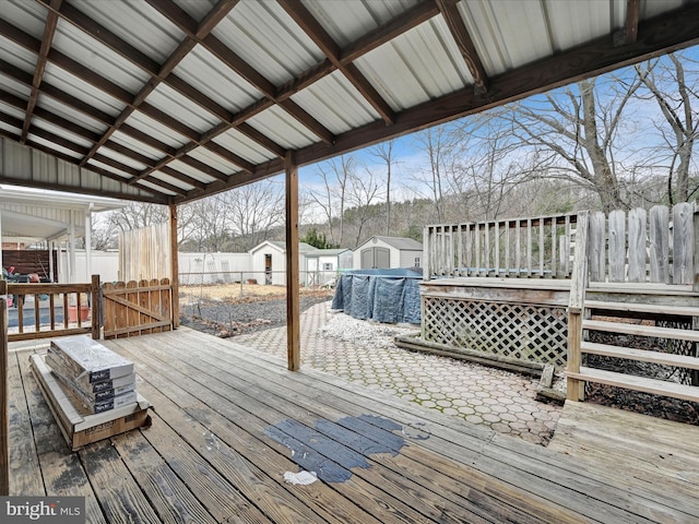 wooden terrace with an outdoor structure, a fenced backyard, and a shed