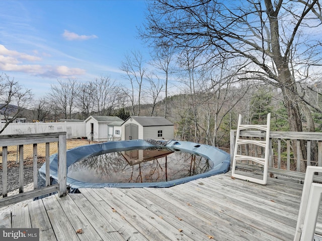 deck featuring a storage shed, an outbuilding, and fence