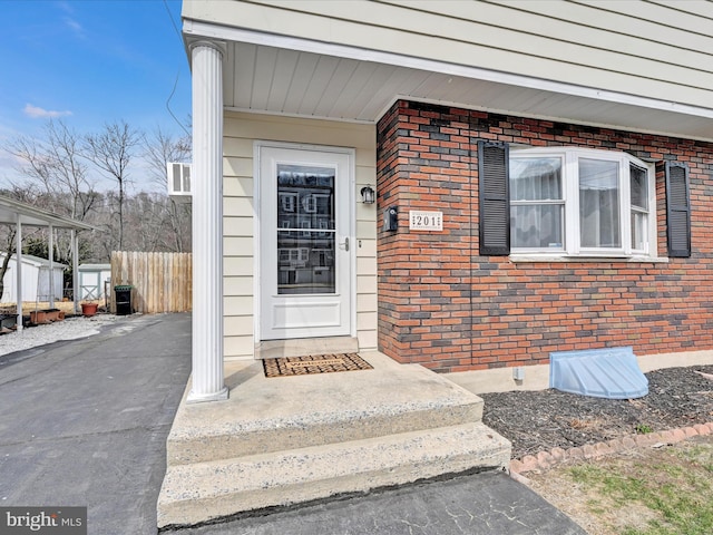 entrance to property with fence and brick siding