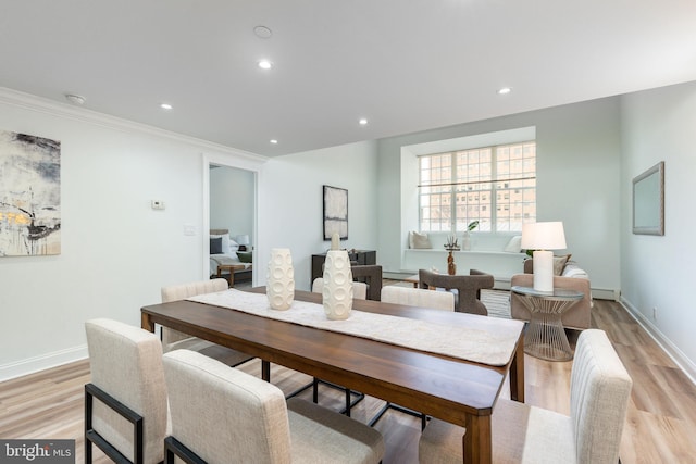 dining area with crown molding, recessed lighting, light wood-style floors, and baseboards