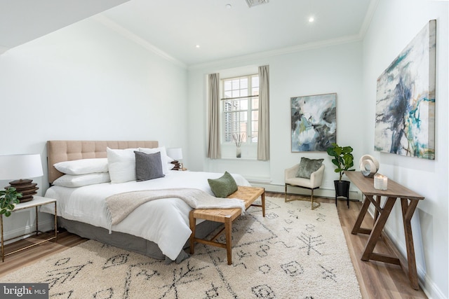 bedroom with visible vents, ornamental molding, wood finished floors, recessed lighting, and baseboard heating