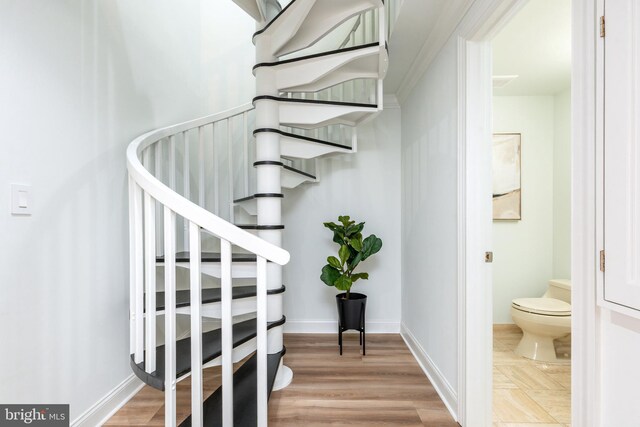 staircase with baseboards and wood finished floors