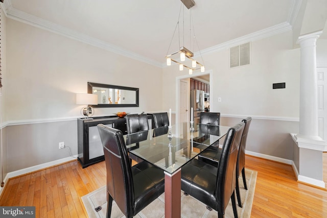 dining area featuring visible vents, crown molding, light wood finished floors, baseboards, and ornate columns