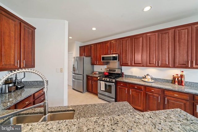 kitchen featuring a sink, recessed lighting, light stone countertops, and stainless steel appliances