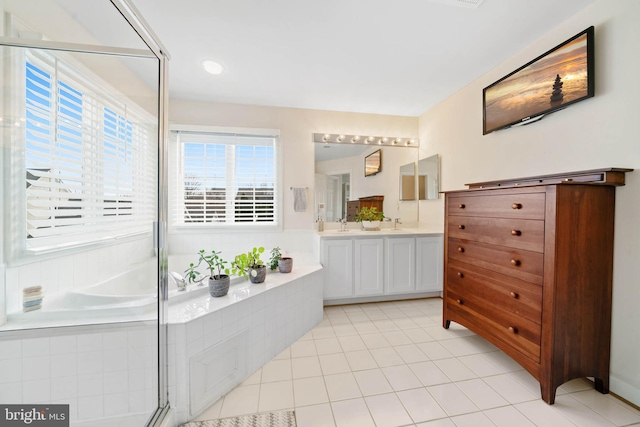 bathroom featuring a bath, tile patterned flooring, a shower with shower door, and double vanity