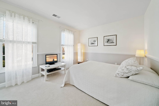 carpeted bedroom featuring visible vents and baseboards