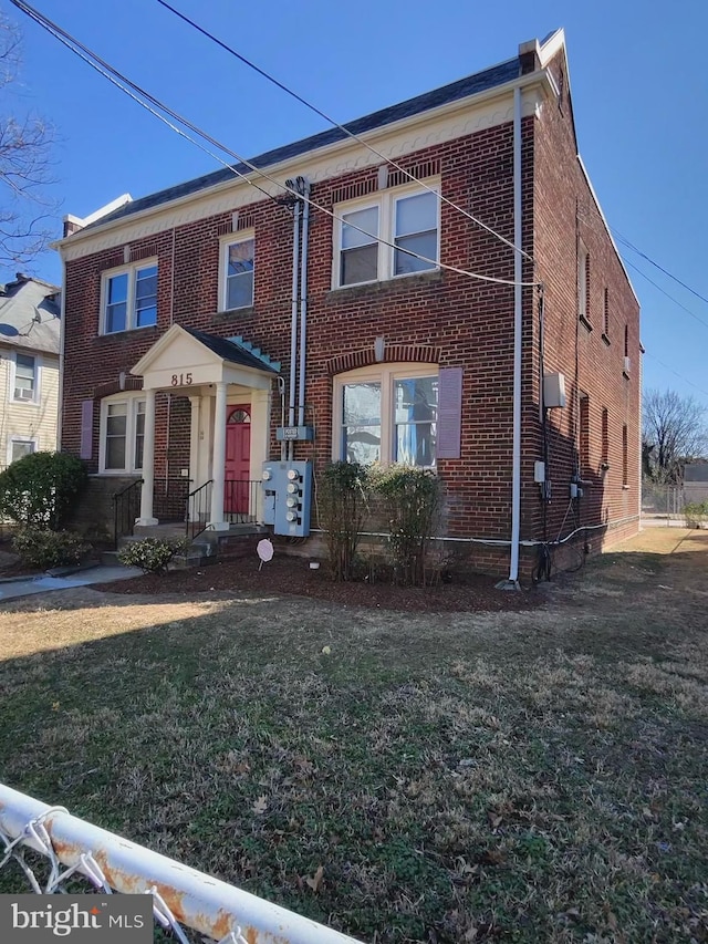 view of property featuring a front yard and brick siding