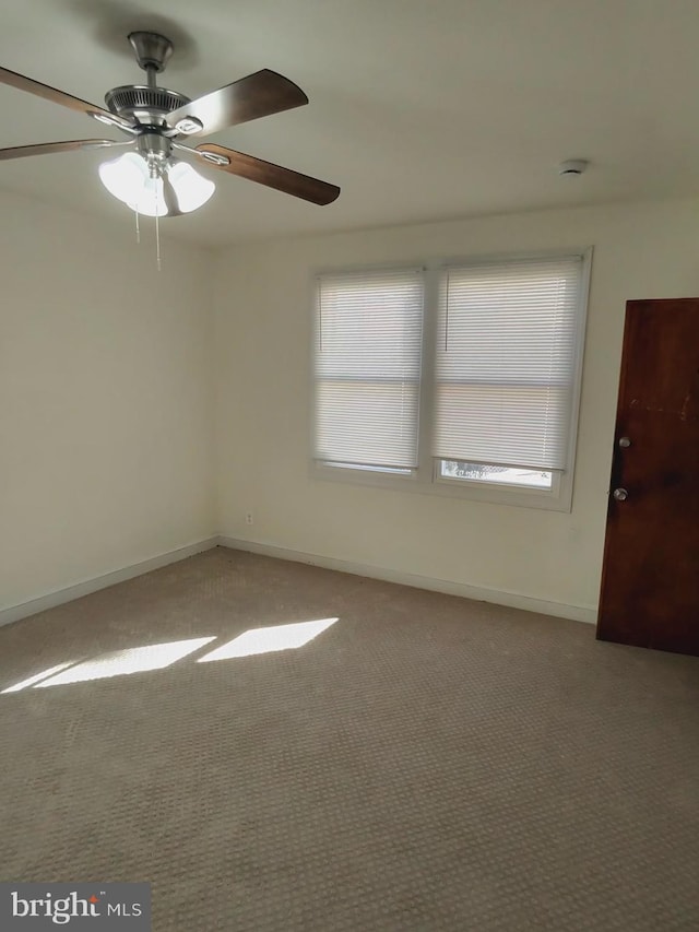 spare room with plenty of natural light, baseboards, carpet floors, and ceiling fan