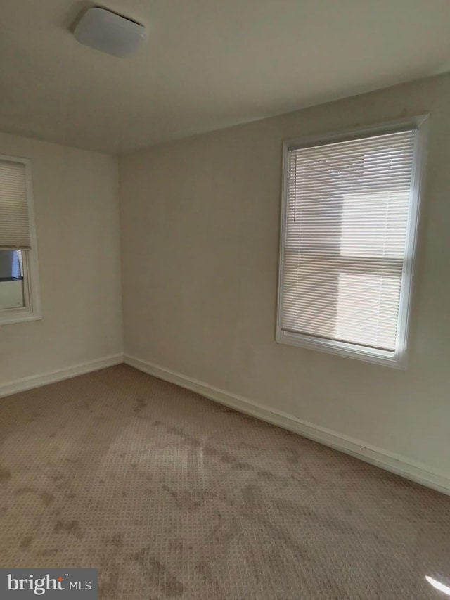 unfurnished room featuring carpet flooring and baseboards