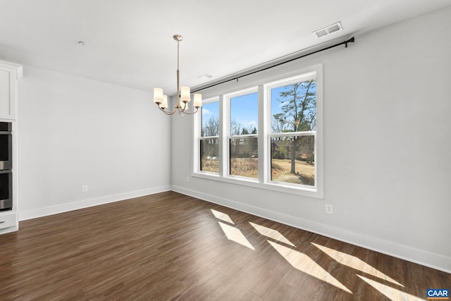 unfurnished room featuring visible vents, baseboards, an inviting chandelier, and dark wood-style flooring