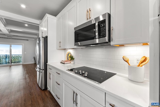 kitchen with tasteful backsplash, beamed ceiling, appliances with stainless steel finishes, dark wood-style floors, and white cabinetry