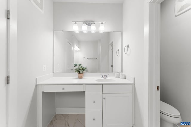 bathroom with vanity, toilet, and marble finish floor