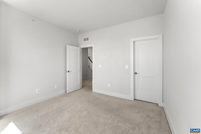 unfurnished bedroom featuring visible vents, baseboards, and carpet floors