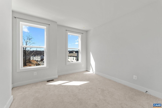 empty room with visible vents, carpet flooring, and baseboards