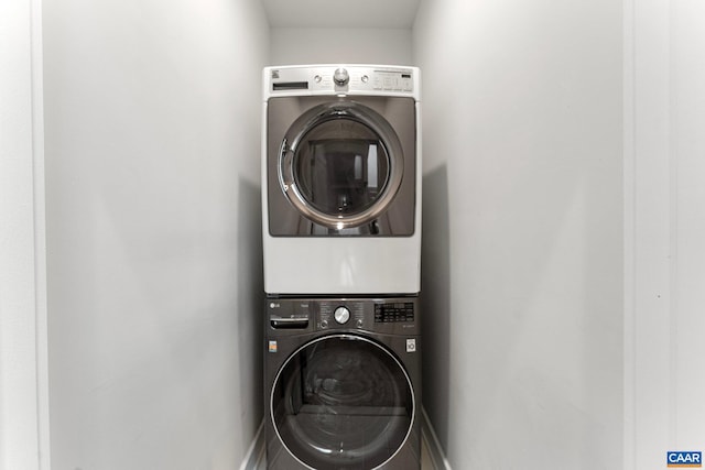 washroom featuring stacked washer and clothes dryer and laundry area