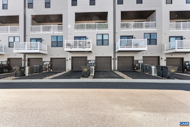 view of property with a garage, central AC unit, and driveway