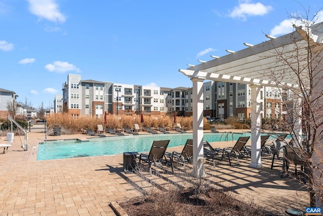 pool with a pergola, a patio, and fence