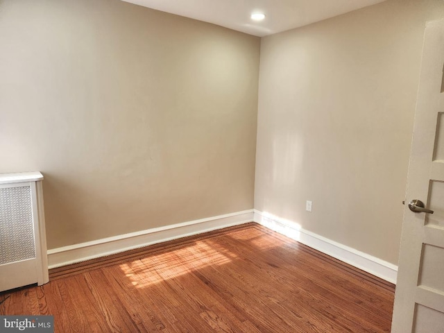 unfurnished room with baseboards and wood finished floors