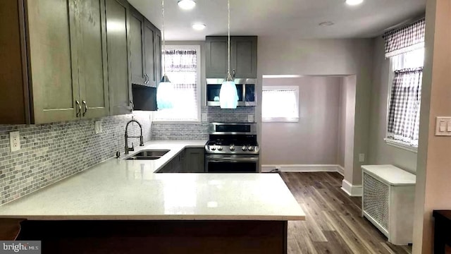 kitchen featuring a sink, backsplash, appliances with stainless steel finishes, and a wealth of natural light