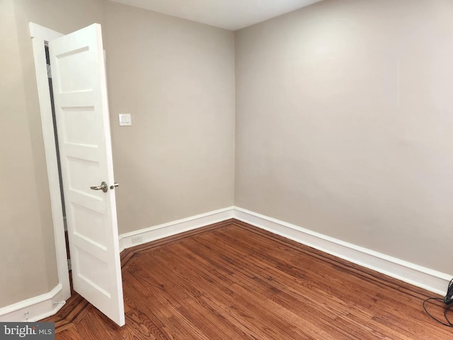 unfurnished room with baseboards and wood finished floors