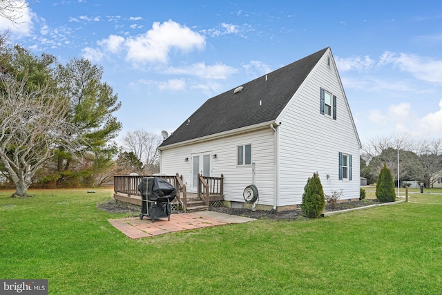 back of house featuring a wooden deck, a lawn, roof with shingles, and a patio area