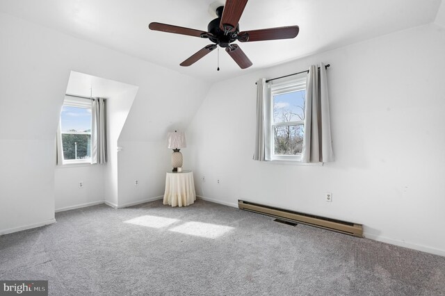 additional living space featuring a baseboard radiator, lofted ceiling, carpet, and baseboards