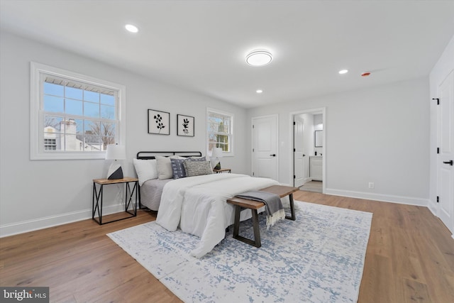 bedroom featuring recessed lighting, baseboards, wood finished floors, and ensuite bathroom