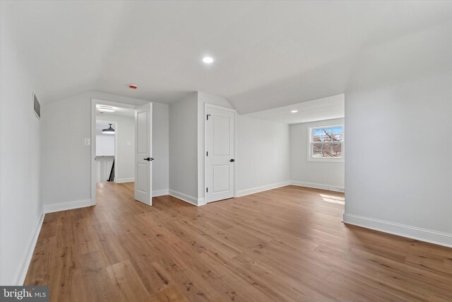 spare room featuring visible vents, baseboards, lofted ceiling, recessed lighting, and light wood-style flooring