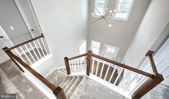 stairway featuring carpet flooring and a towering ceiling