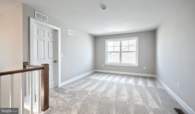 carpeted spare room featuring visible vents and baseboards