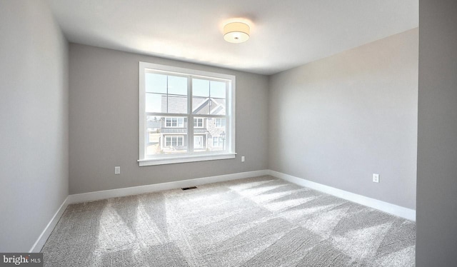 spare room featuring visible vents, carpet flooring, and baseboards