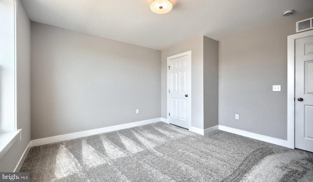 unfurnished bedroom featuring a closet, visible vents, carpet flooring, and baseboards