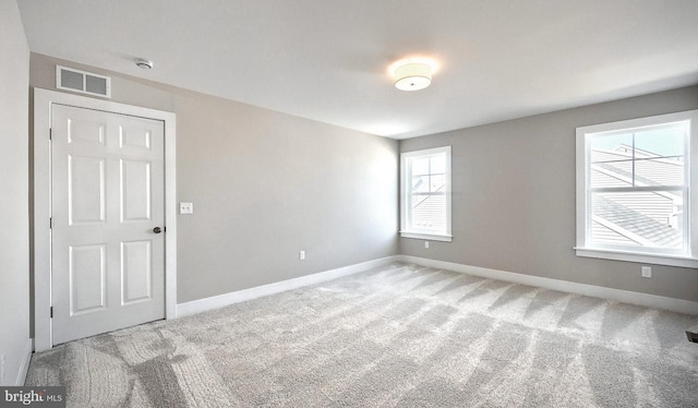 spare room featuring visible vents, baseboards, and carpet