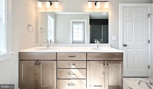 bathroom featuring double vanity, marble finish floor, and a sink