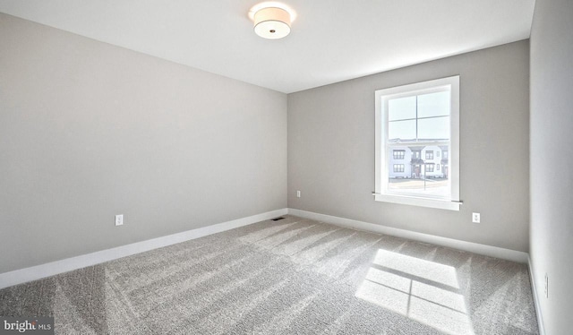 spare room with visible vents, baseboards, and carpet floors