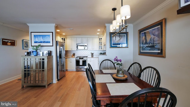 dining room with light wood-style flooring, recessed lighting, baseboards, and ornamental molding