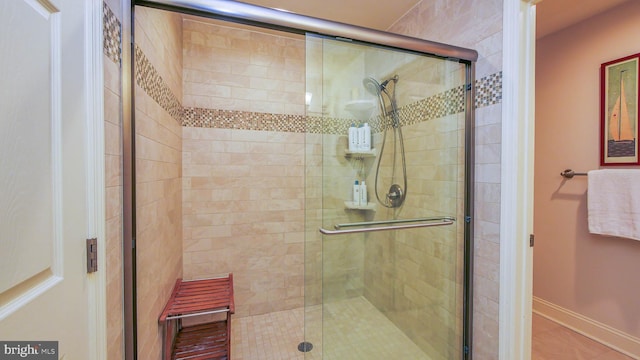 bathroom with a stall shower and baseboards