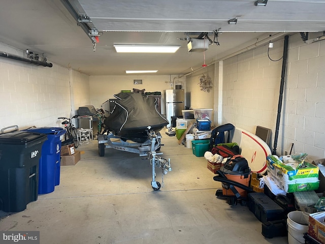 garage with a garage door opener and freestanding refrigerator