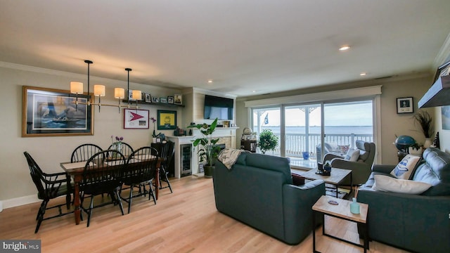 living room featuring light wood-style flooring, ornamental molding, recessed lighting, a fireplace, and baseboards