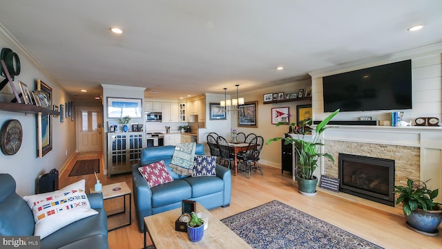 living area featuring recessed lighting, baseboards, light wood-style flooring, and crown molding