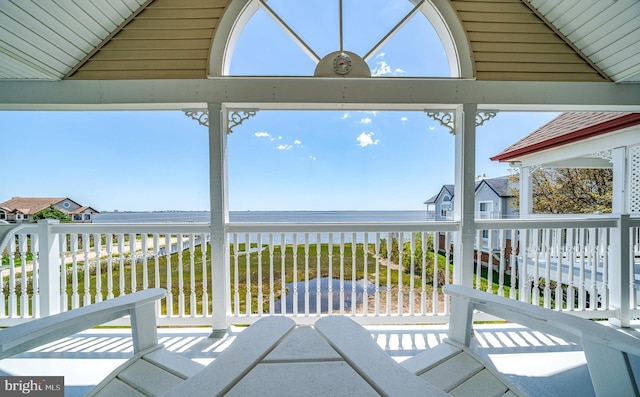 unfurnished sunroom with a water view and vaulted ceiling