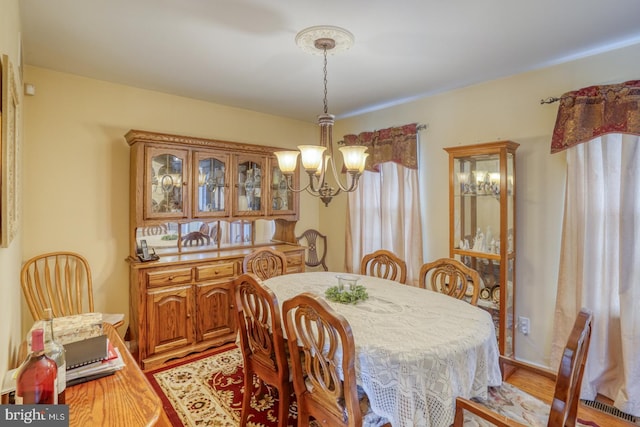 dining area with light wood-style flooring and a chandelier