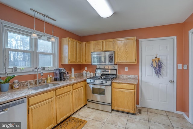 kitchen with light tile patterned floors, appliances with stainless steel finishes, light countertops, and a sink