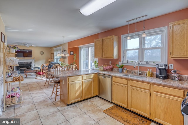 kitchen with a sink, open floor plan, a peninsula, light tile patterned floors, and dishwasher