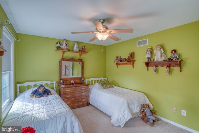 carpeted bedroom with visible vents, baseboards, and a ceiling fan