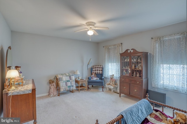 sitting room featuring carpet, baseboards, and ceiling fan