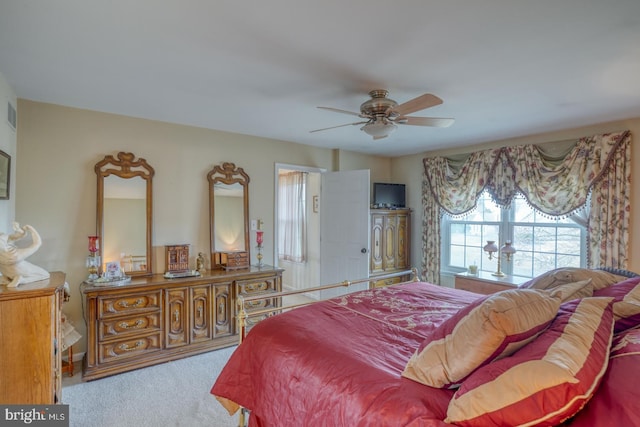 carpeted bedroom featuring a ceiling fan and visible vents