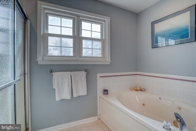 bathroom with baseboards and a jetted tub